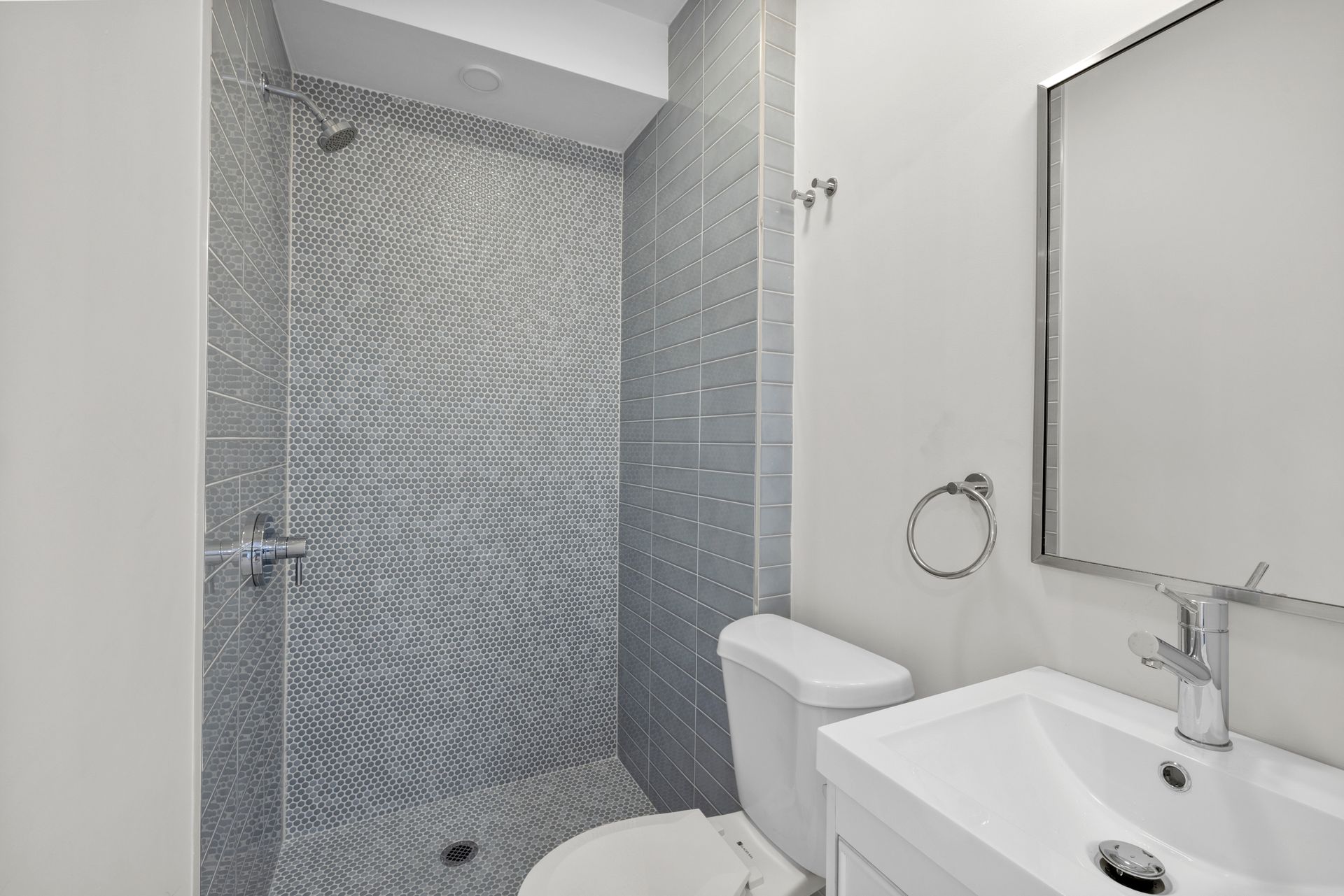 A bathroom with a toilet , sink and shower.