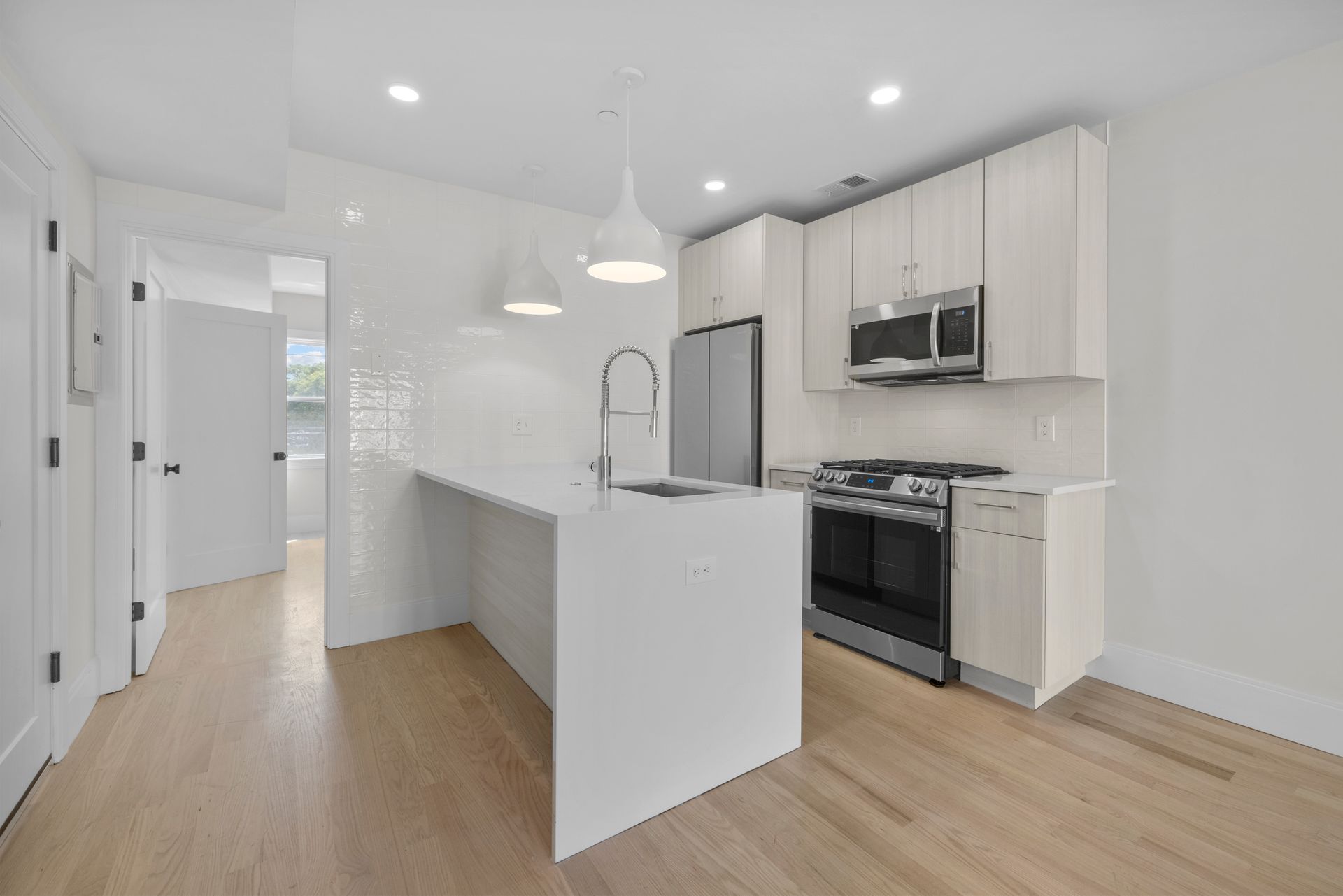 A kitchen with white cabinets and stainless steel appliances