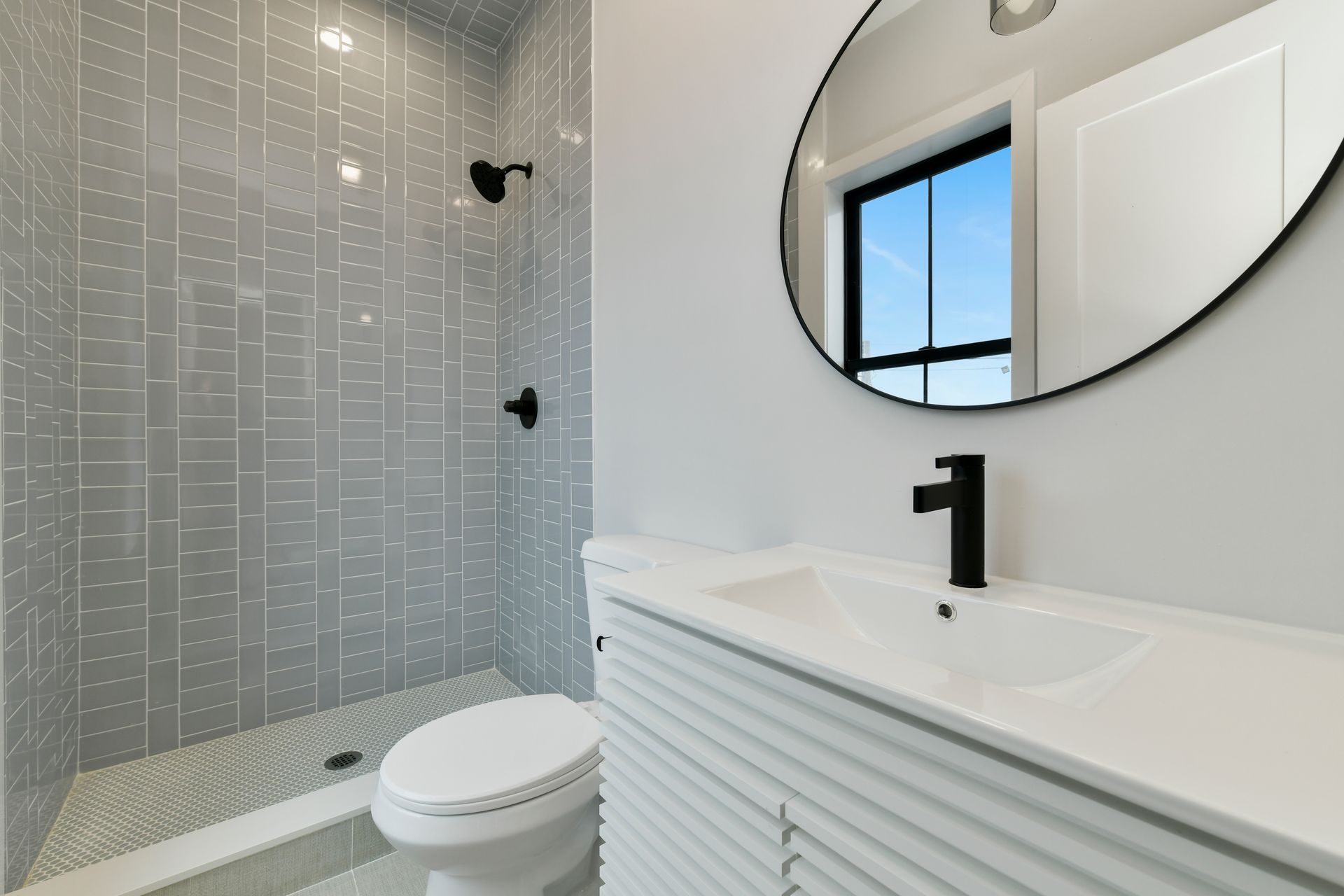 A bathroom with a toilet , sink , and shower.