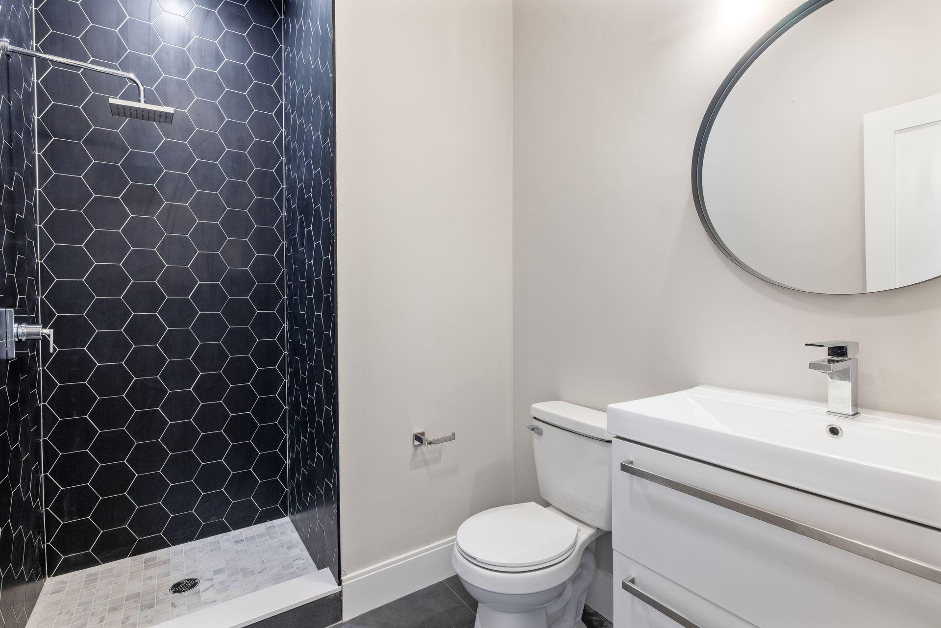 A bathroom with a toilet , sink and shower.