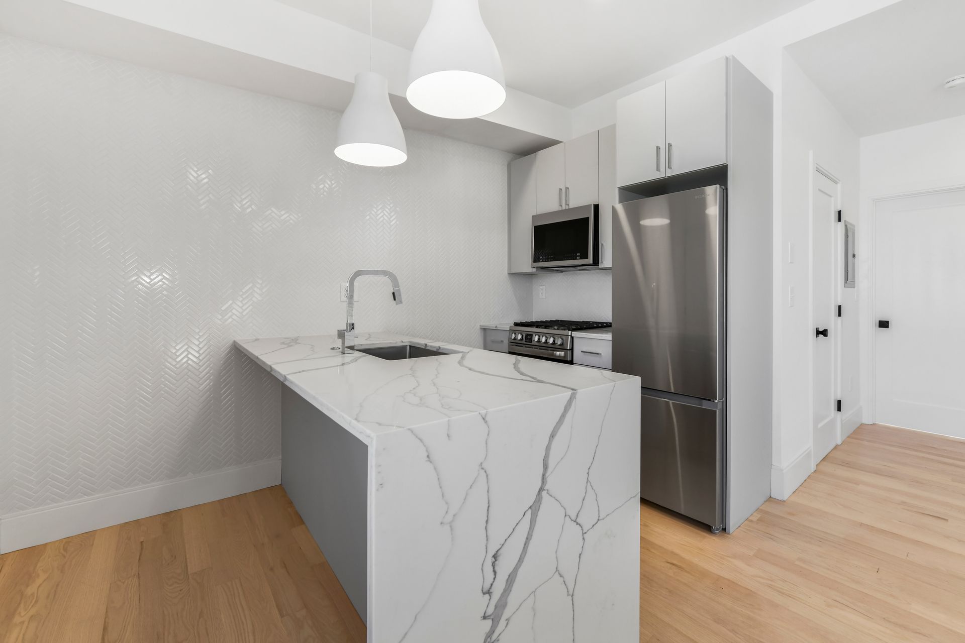 A kitchen with a marble counter top and stainless steel appliances