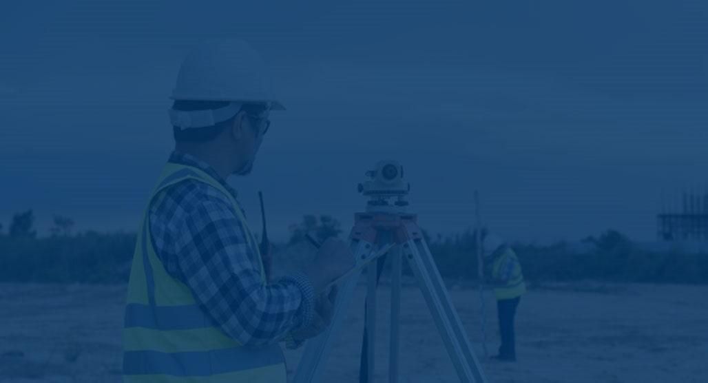 Topógrafos utilizando equipo en un sitio de construcción, tinte azul.