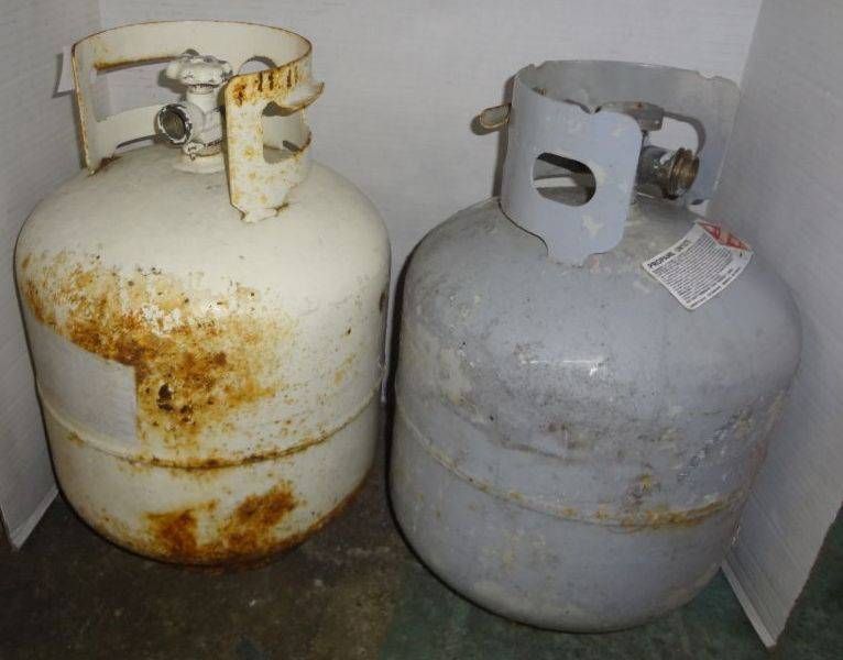 Two gas cylinders are sitting next to each other on a table.