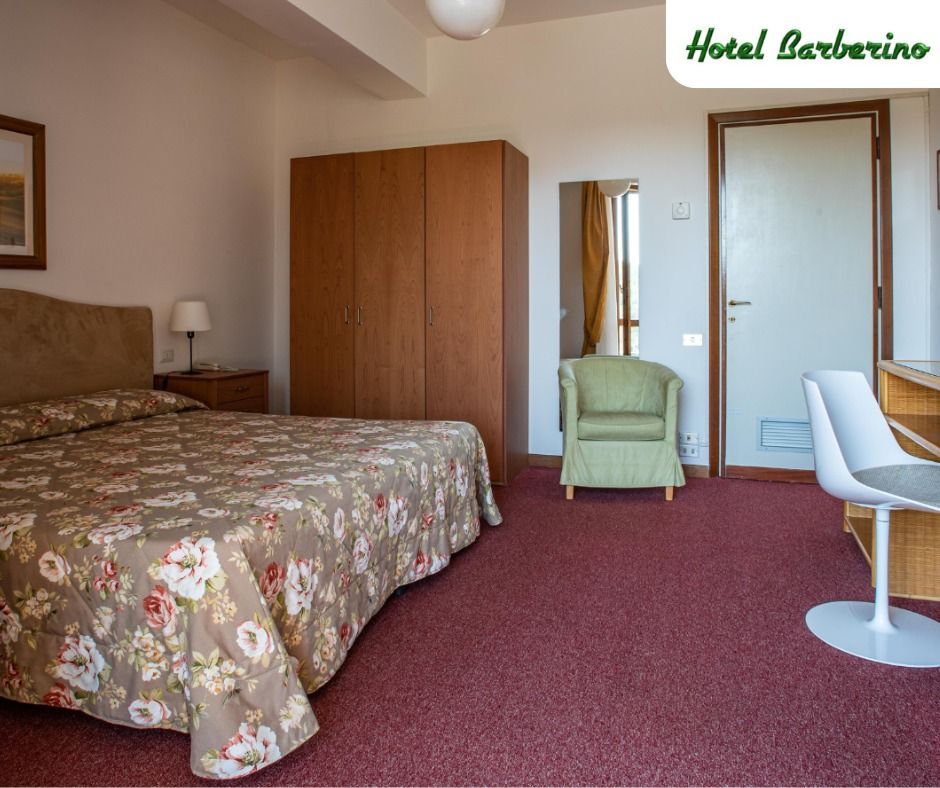 Una camera d'albergo con un letto, una sedia e una scrivania