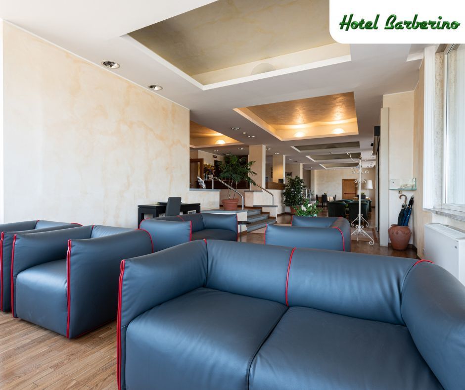 Una hall di un hotel con un sacco di divani e sedie