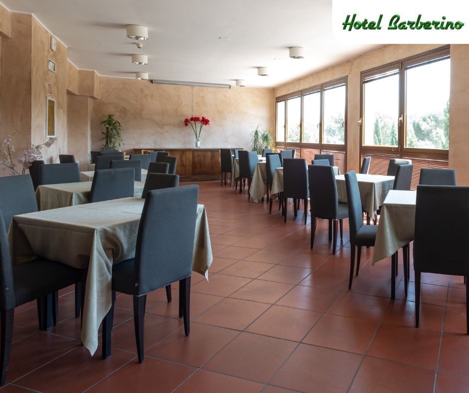 Un ristorante con tavoli e sedie e un cartello con scritto hotel barbarino