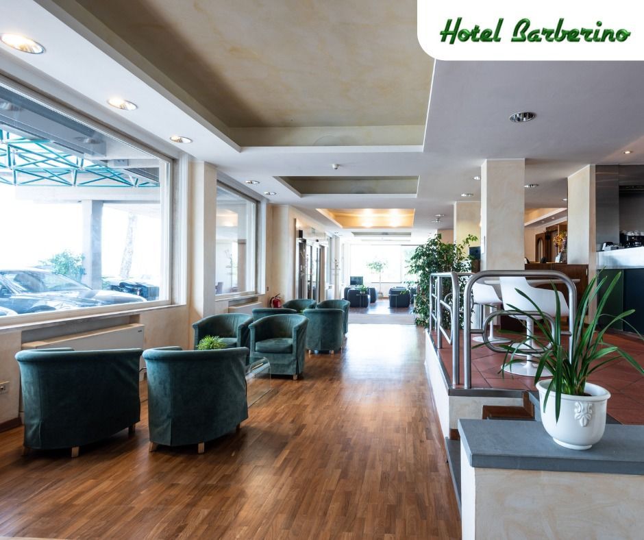 Una hall dell'hotel con sedie verdi e una pianta in vaso