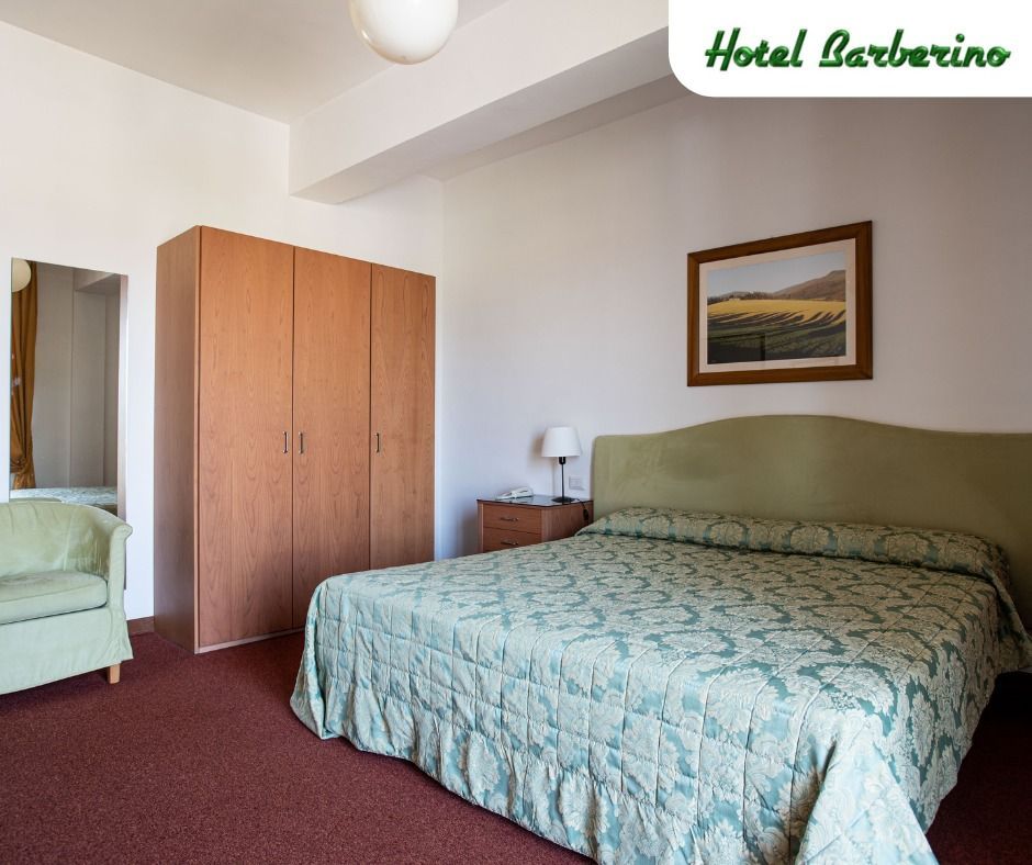 Una camera d'albergo con un letto grande e una sedia