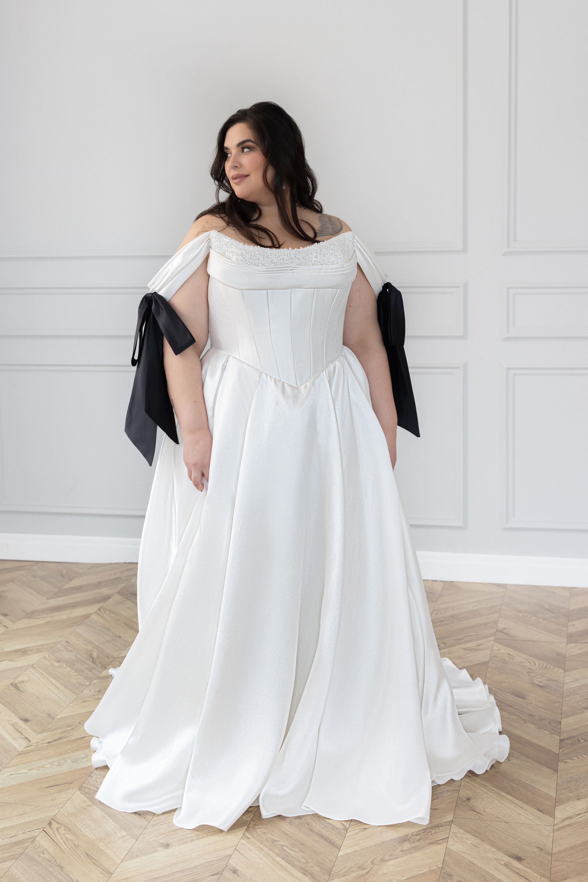 plus size bride wearing a white and black wedding gown in a ballroom