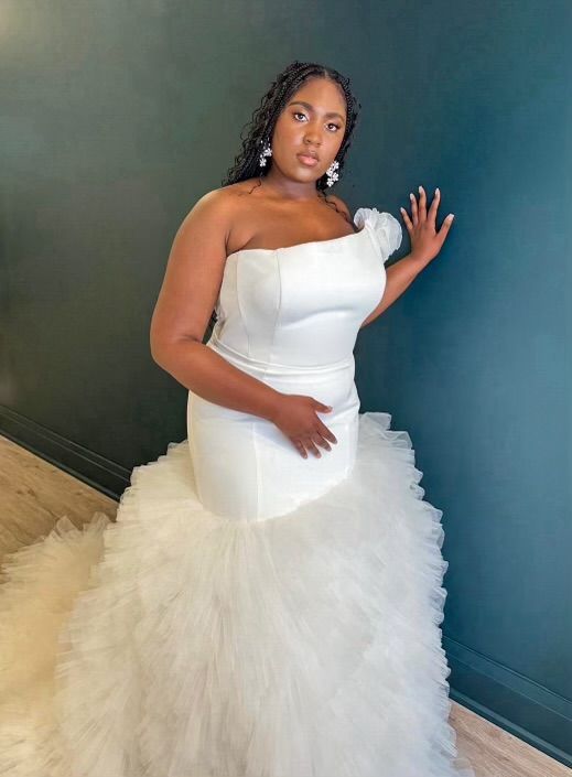 girl in wedding gown in front of green wall