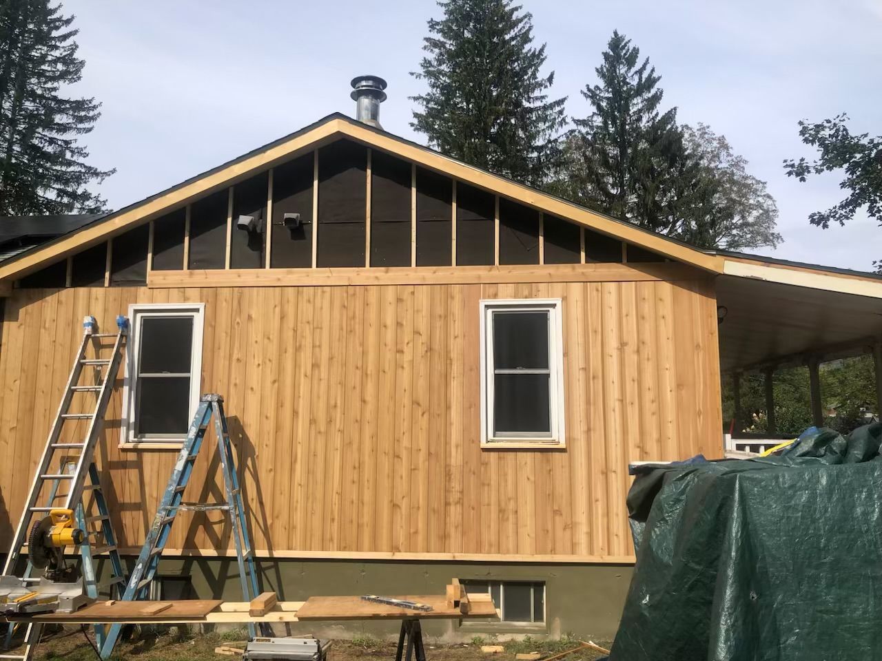 A wooden house with a ladder and a table in front of it
