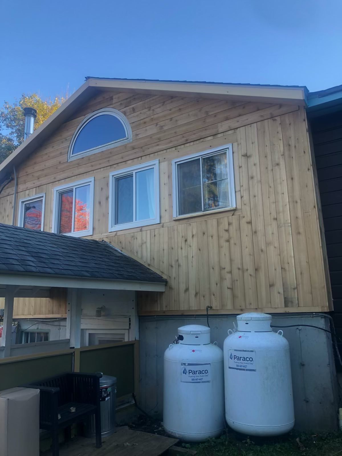 A house with two propane tanks on the side of it.