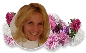 A blonde person smiling, framed by a circular border surrounded by a cluster of pink, purple, and white asters.