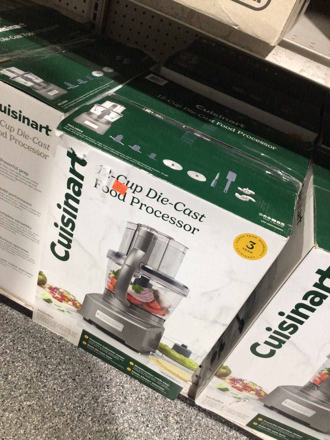 A cuisinart food processor is sitting on a shelf in a store.