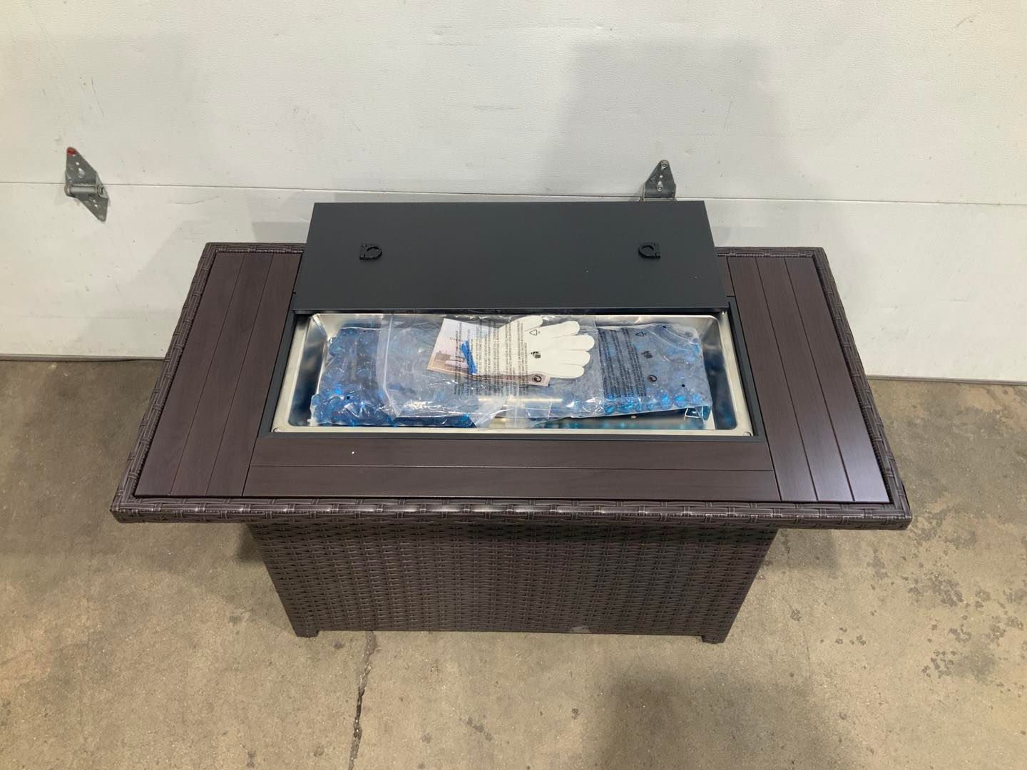 A wicker coffee table with a cooler inside of it.