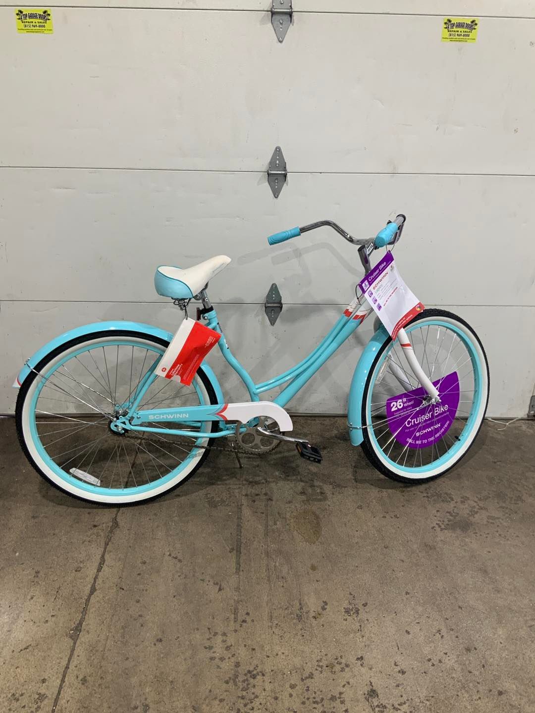 A blue bicycle is parked in front of a garage door.