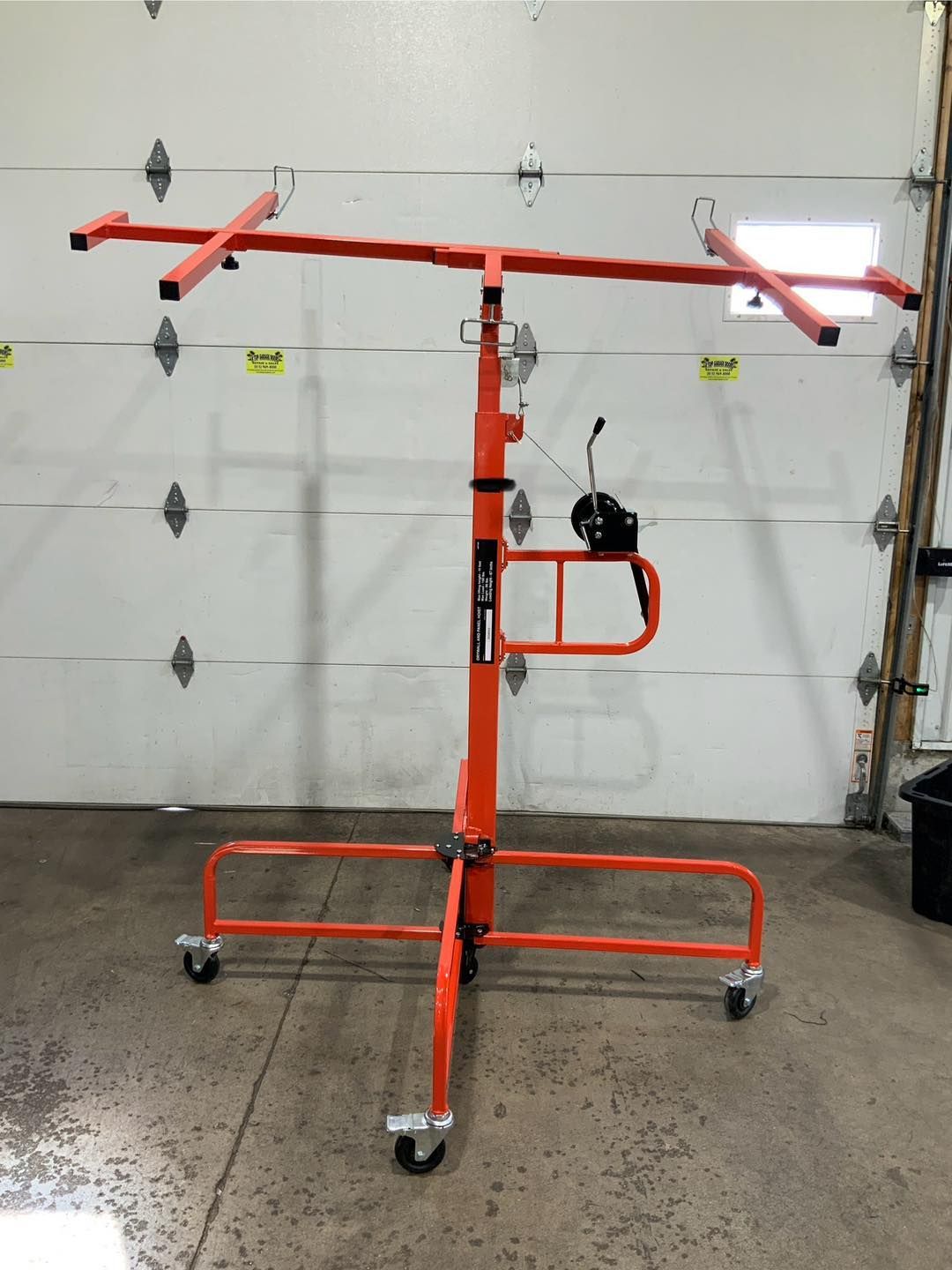 An orange stand with wheels is in front of a garage door