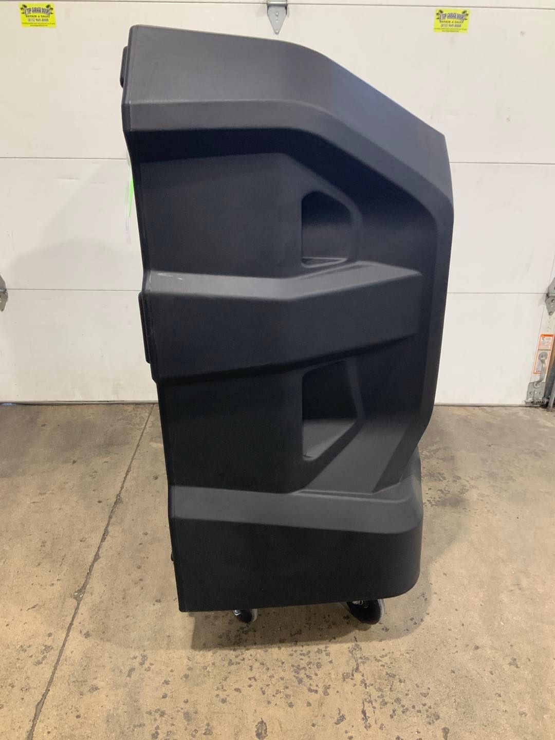 A large black box is sitting in front of a garage door