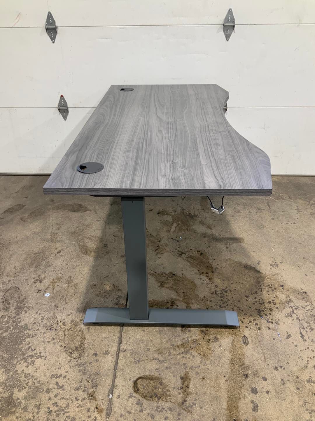A standing desk is sitting in front of a garage door.