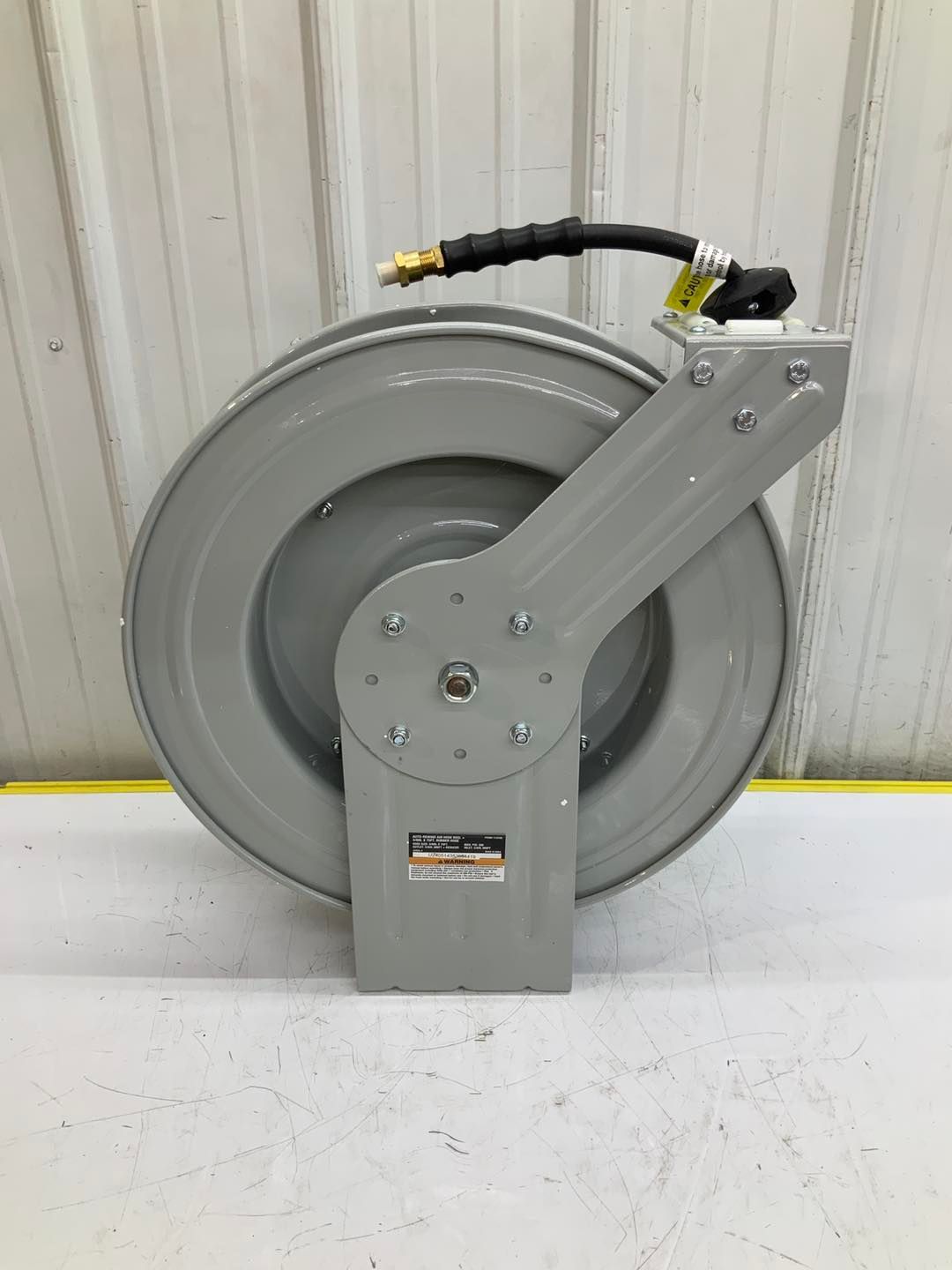 A hose reel is sitting on top of a white table.