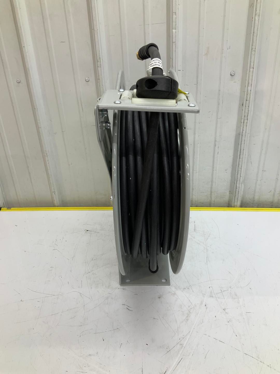 A hose reel is sitting on top of a white table.