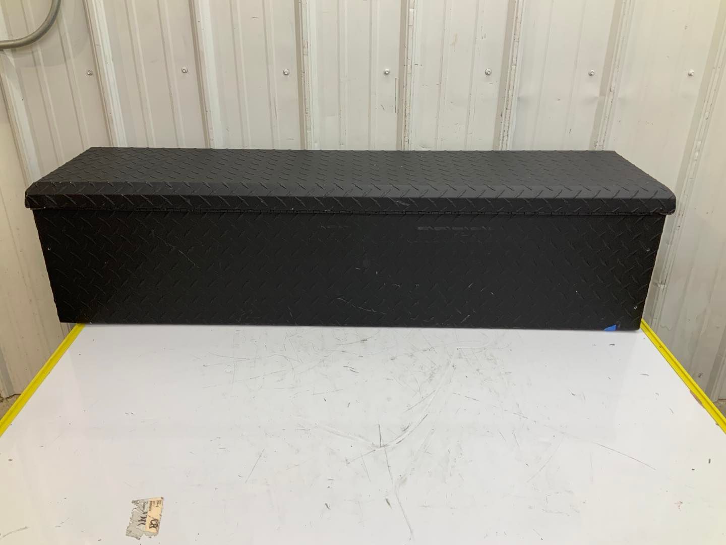 A black toolbox is sitting on top of a white table.