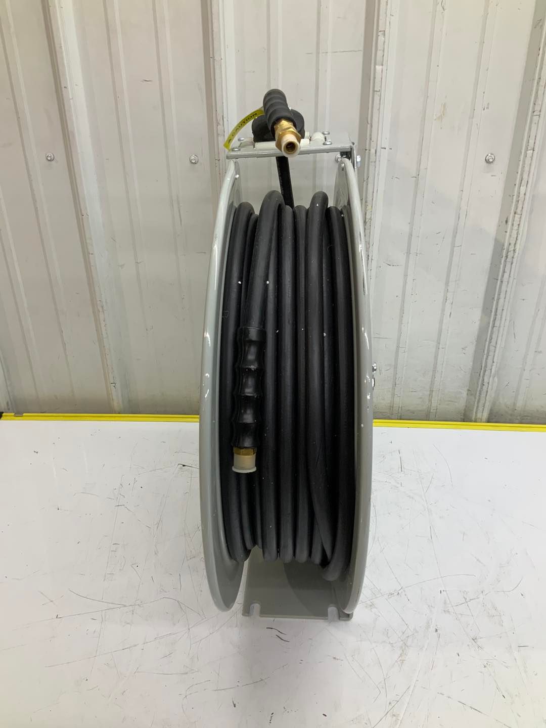 A hose reel with a hose attached to it is sitting on a table.