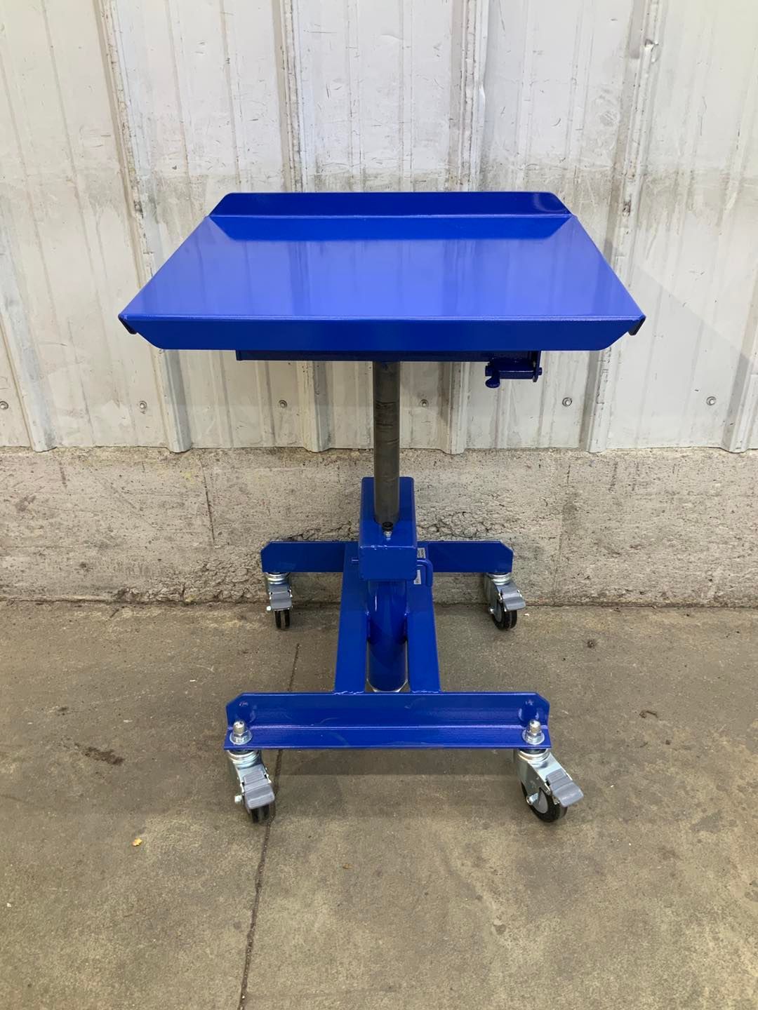 A blue table with wheels and a tray on top
