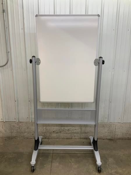 A white board is sitting on top of a metal stand with wheels.