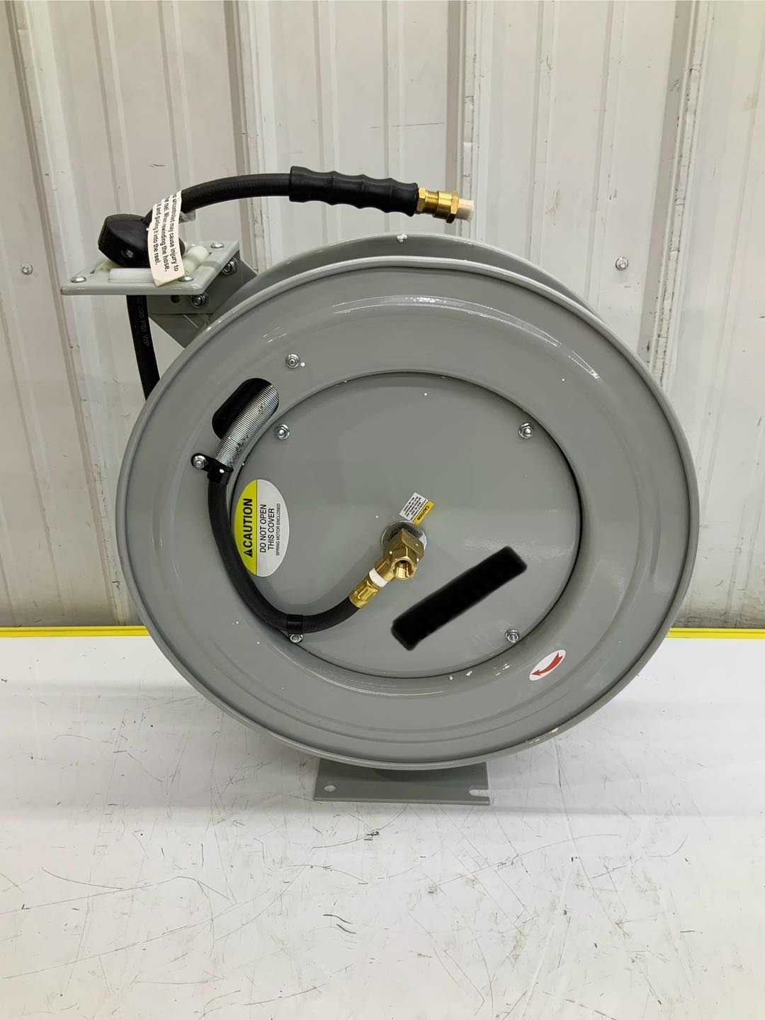 A hose reel with a hose attached to it is sitting on a table.