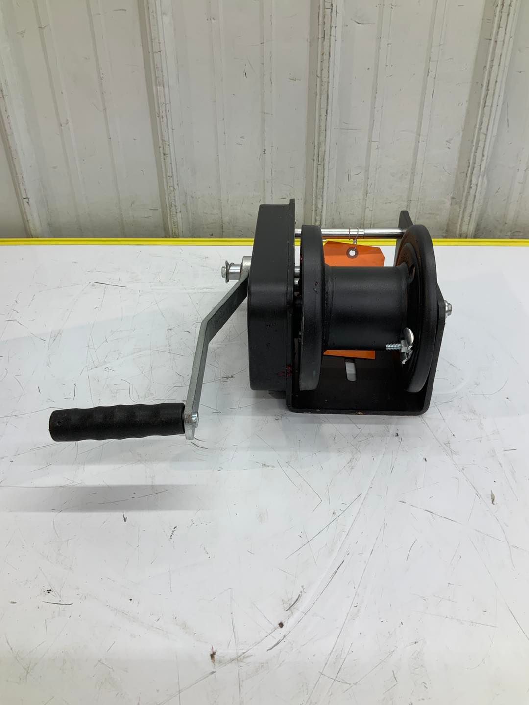 A hand winch is sitting on top of a white table.