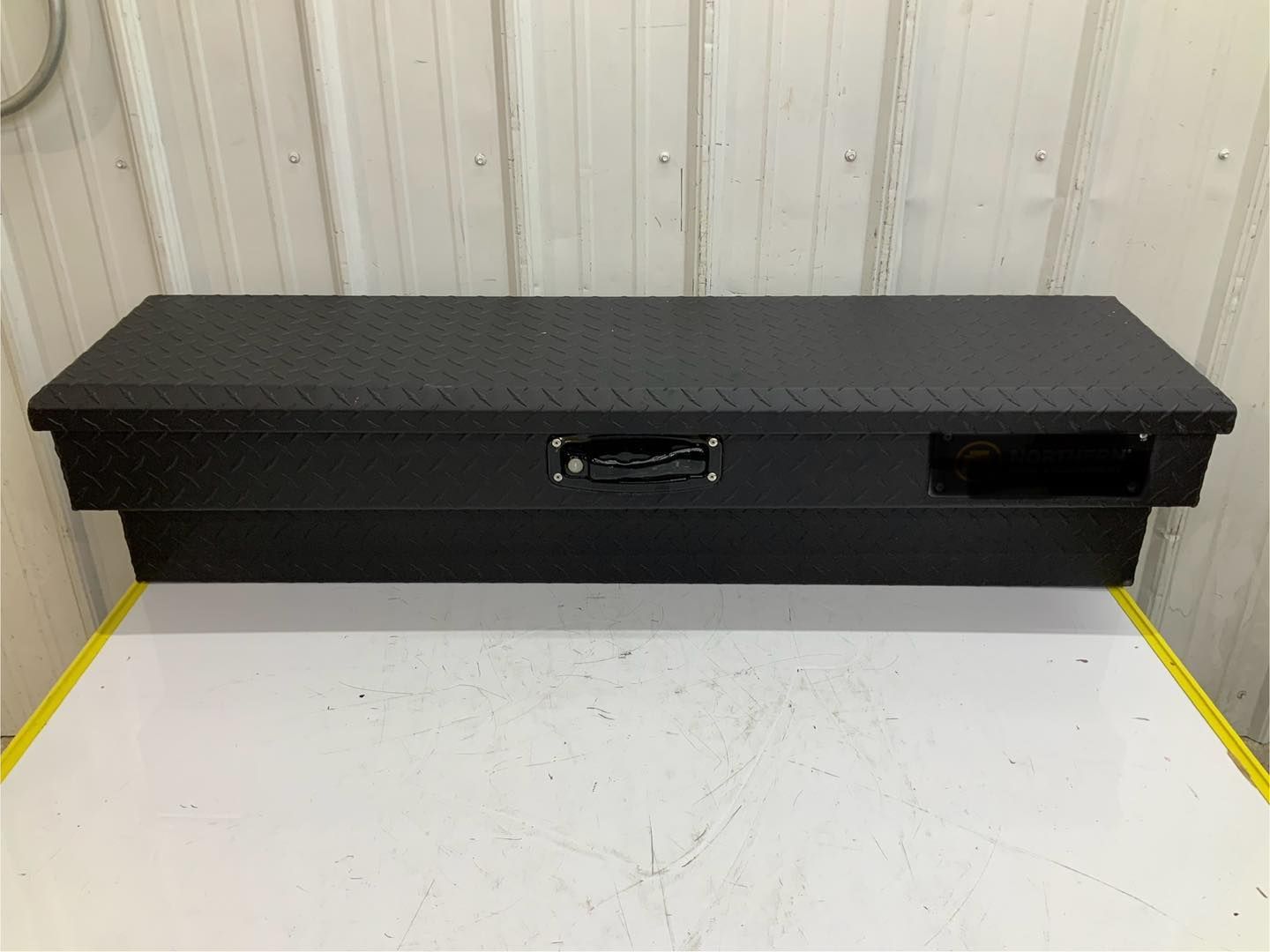 A black toolbox is sitting on top of a white table.