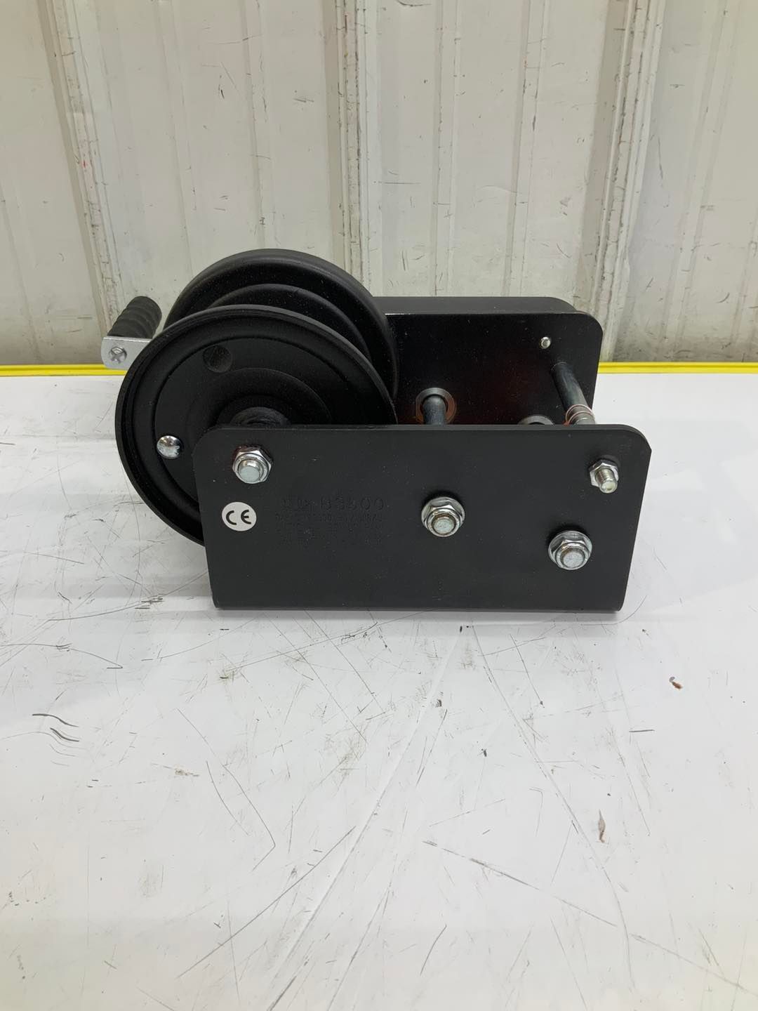 A black winch is sitting on top of a white table.