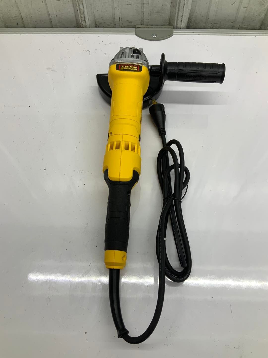 A yellow and black grinder is sitting on a white surface.