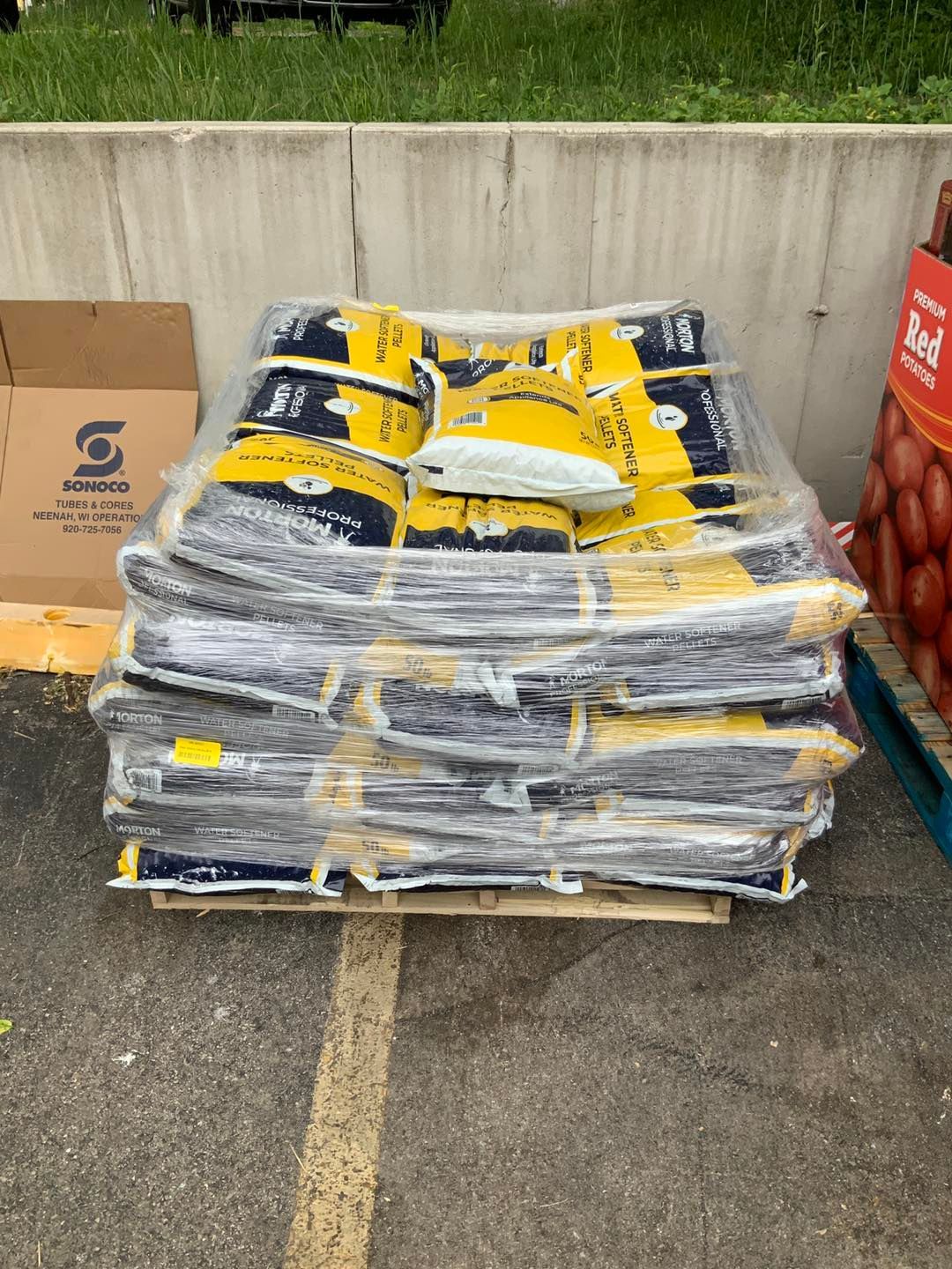 A pile of bags sitting on top of a wooden pallet.