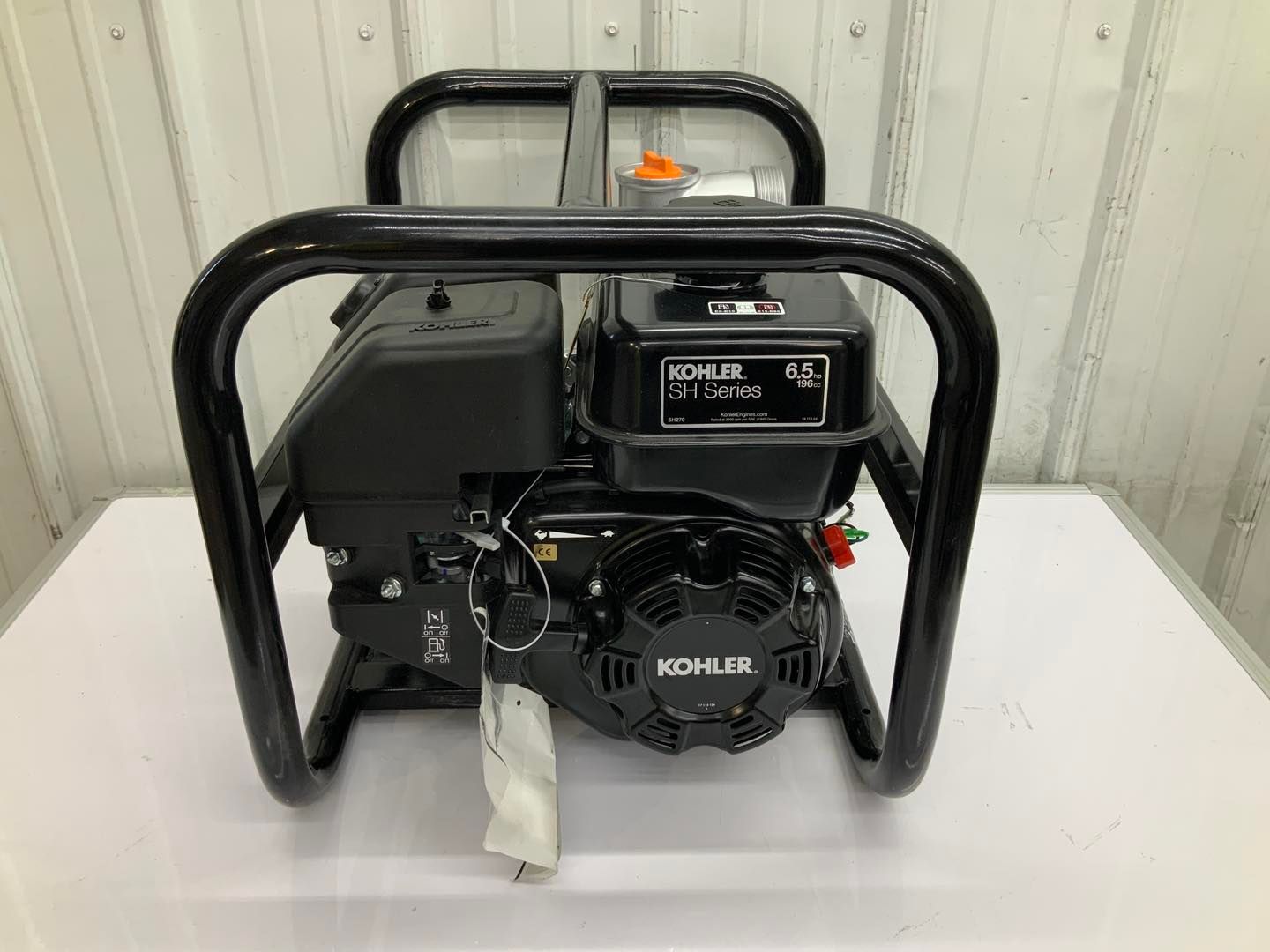 A black generator is sitting on top of a white table.