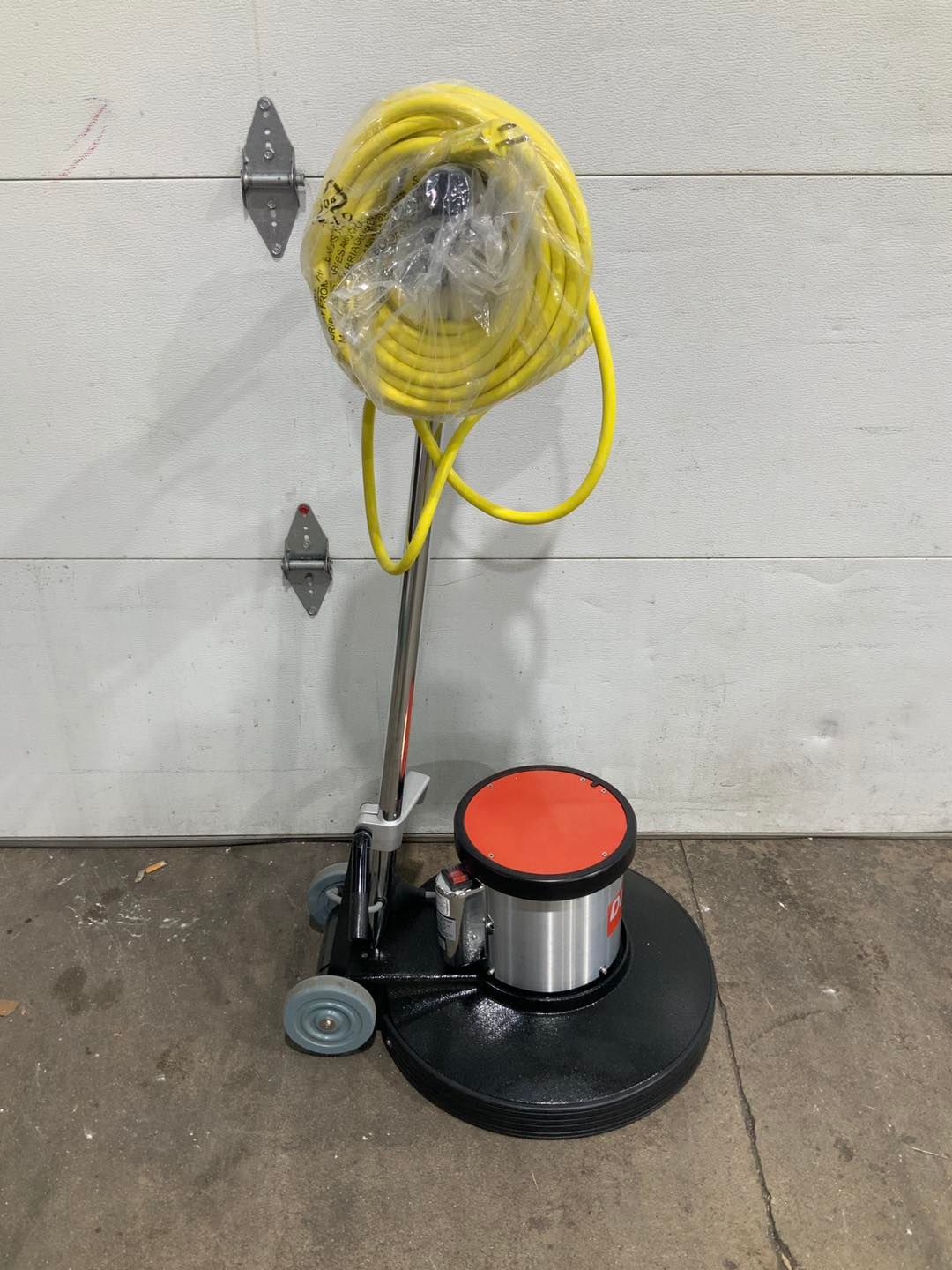 A vacuum cleaner with a yellow cord attached to it