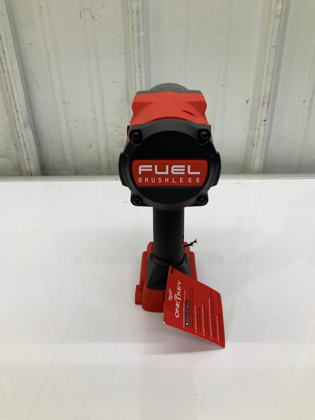 A fuel brushless impact wrench is sitting on a white table.