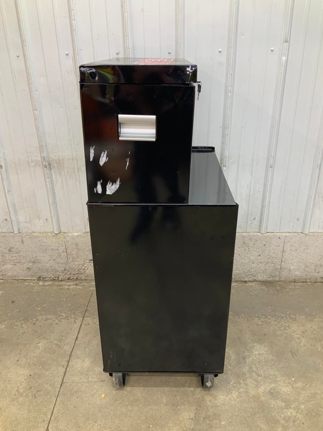 A black box is sitting on top of a black cabinet.