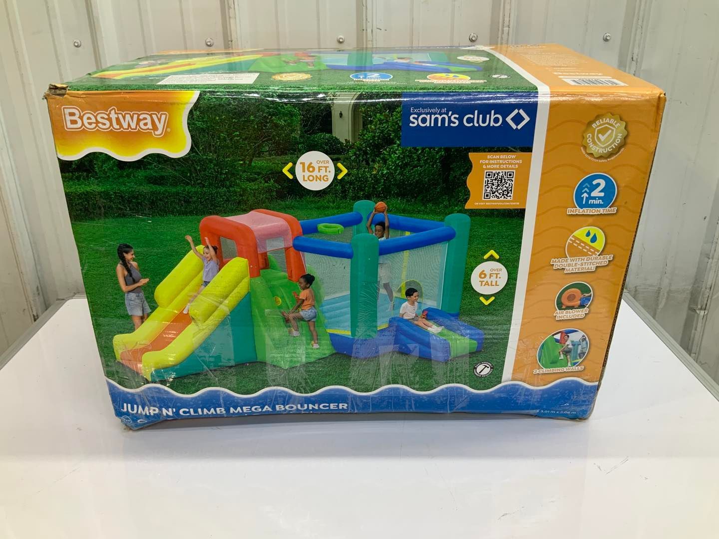 A box of a bouncy house with a slide in it