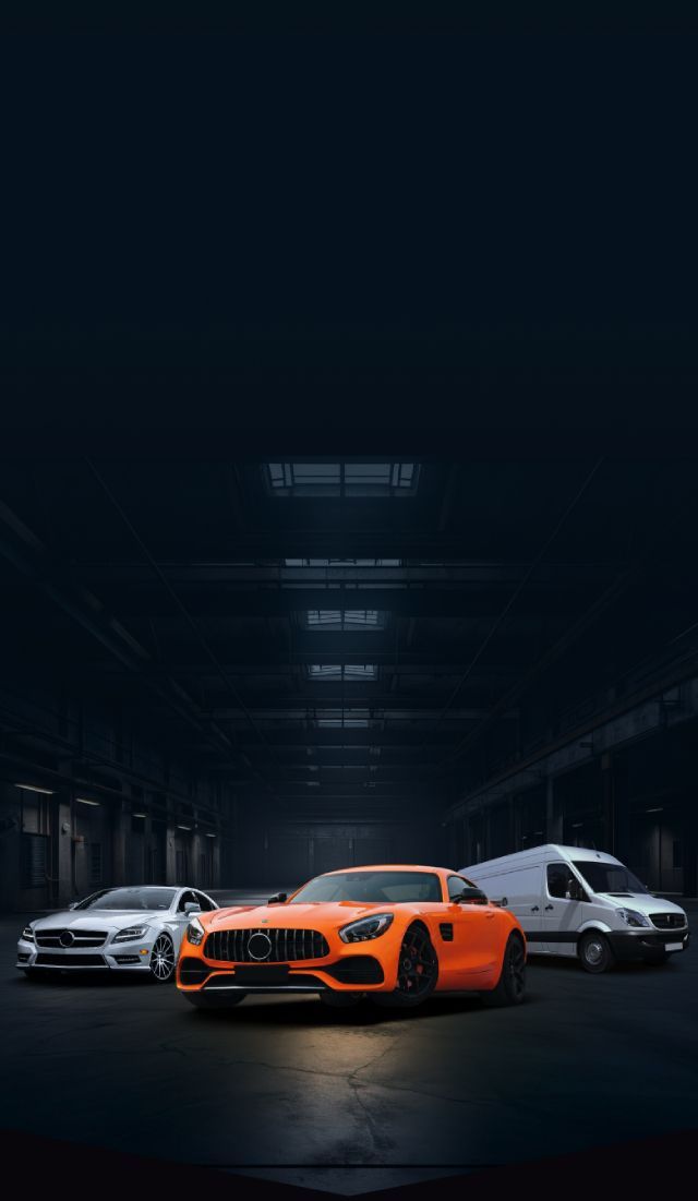 Three sports cars in a dark garage, with an orange coupe centered between white cars. | Sam Smith Performance Car Care Center