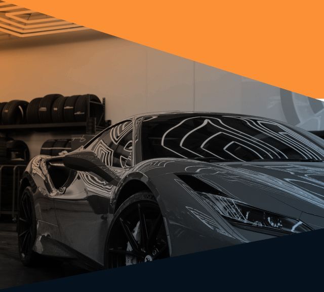 Gray sports car in a modern showroom, reflecting ceiling lights | Sam Smith Performance Car Care Center