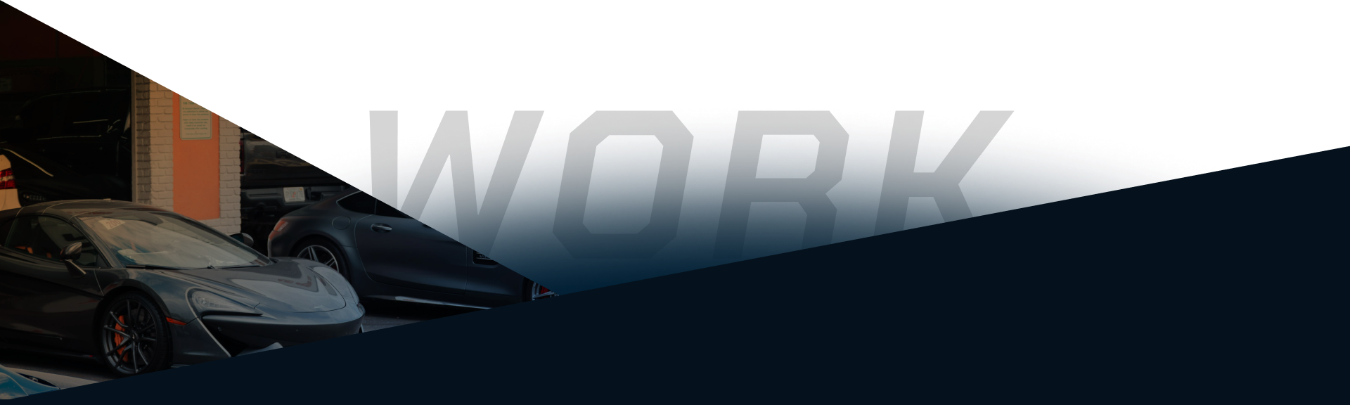 Dark, low-angle view of a car in a workshop, with large “WORK” text in the background | Sam Smith Performance Car Care Center