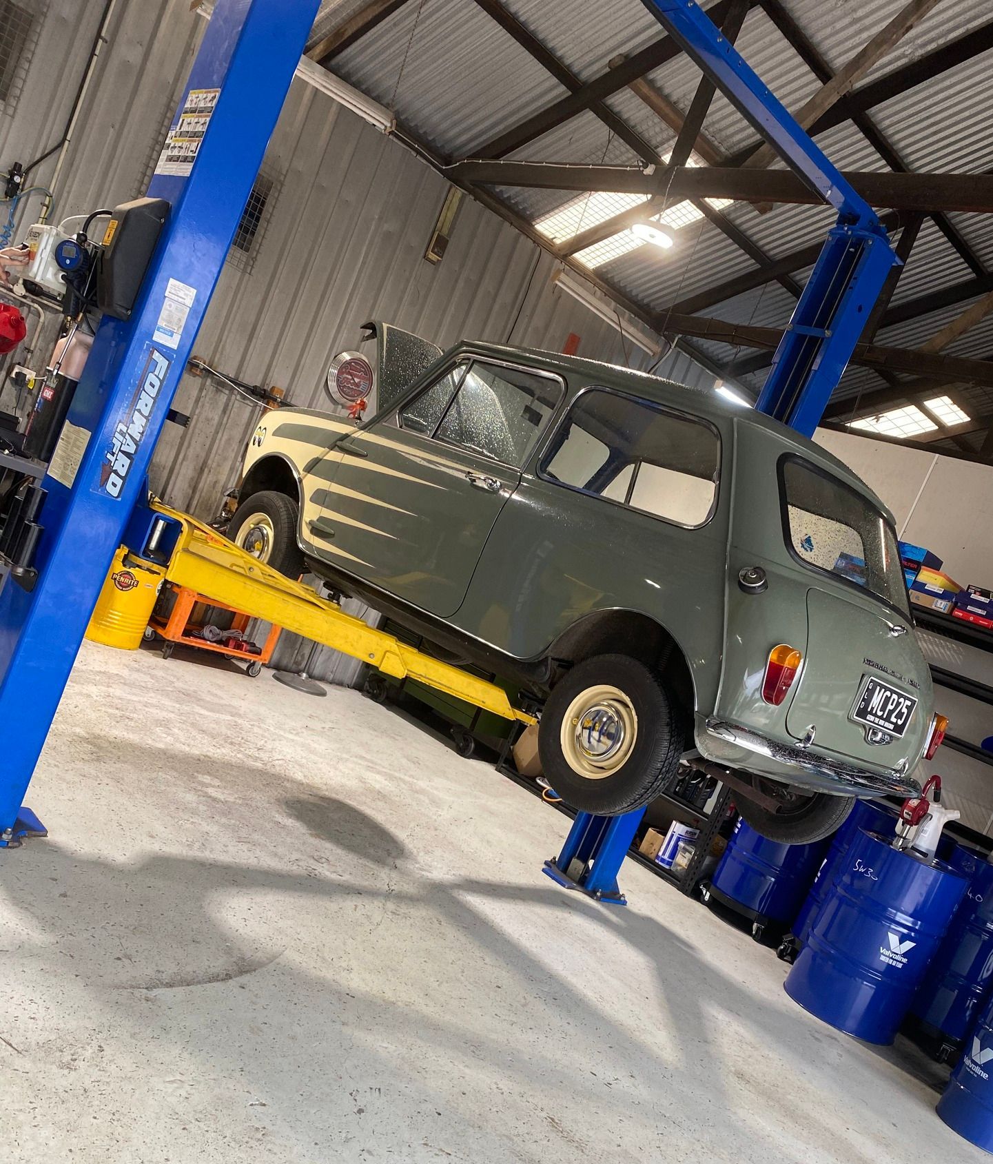 A car is sitting on a lift in a garage — Murphys Mobile Mechanical In Rockhampton, QLD