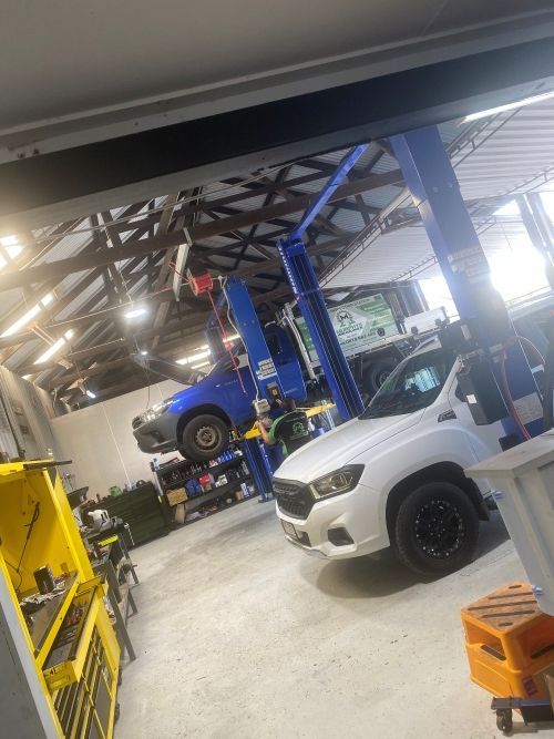A White Truck Is Sitting On A Lift In A Garage — Murphys Mobile Mechanical In Rockhampton, QLD