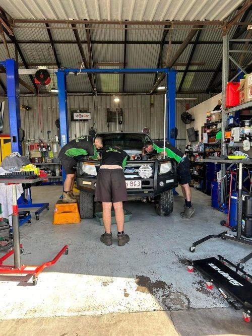 A Group Of People Are Working On A Car In A Garage — Murphys Mobile Mechanical In Rockhampton, QLD