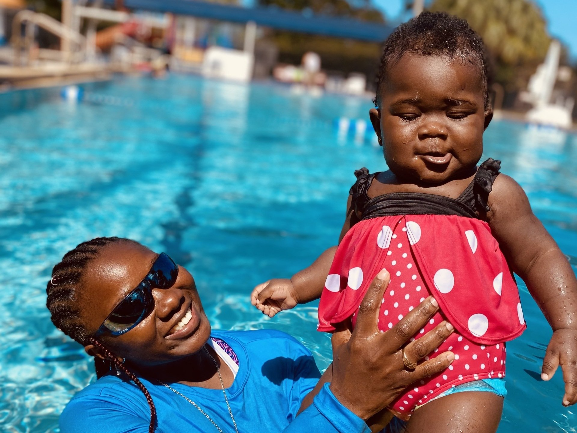 Happy Coach Pat Holding Cute Little Baby — Sunrise, FL — Pat's Swimming Academy
