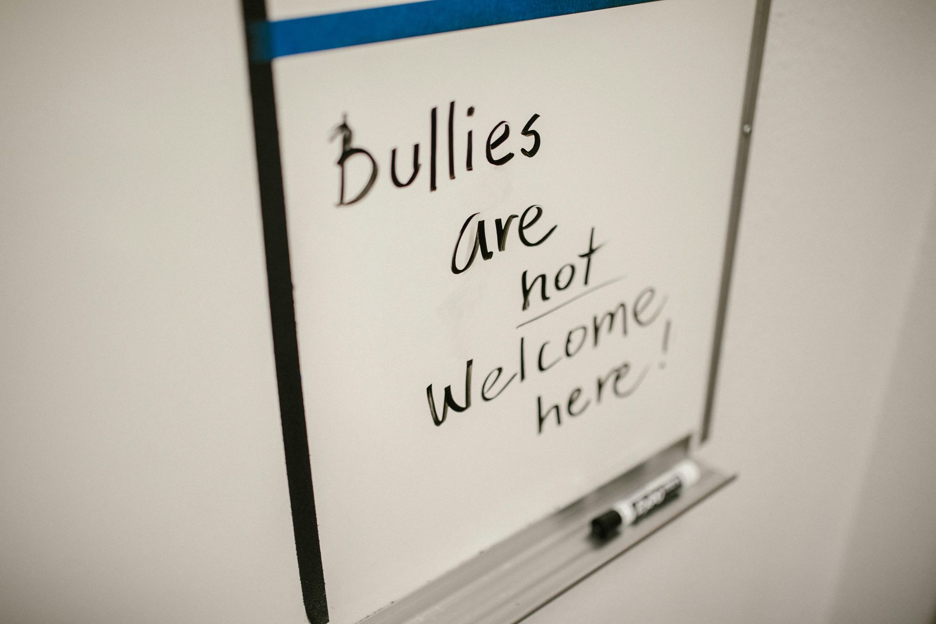 White board with "Bullies are not welcome here" message