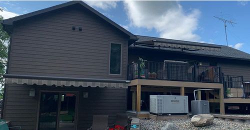 A large house with a large deck and a large roof.