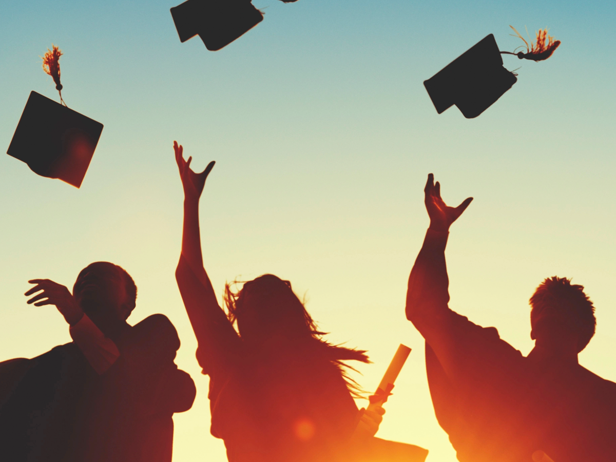 graduates throwing caps in the air